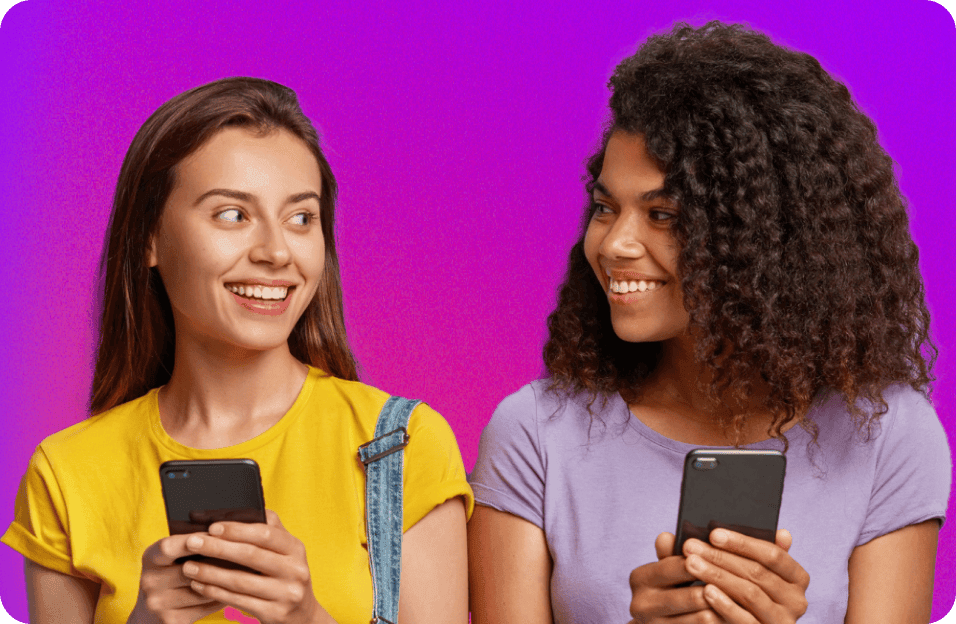 duas garotas sorrindo uma para outra enquanto usam o app Vivae